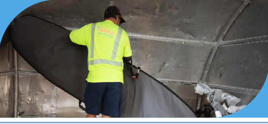 A Cargo Service Agent loading a surfboard onto a plane.